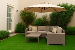 جلسة خارجية في حديقة منزلية بالصالحية، كنبة زاوية وطاولة بسيطة، مظلة، وثيل ونباتات خضراء